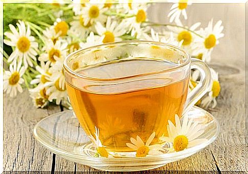 Chamomile tea with flowers in the background