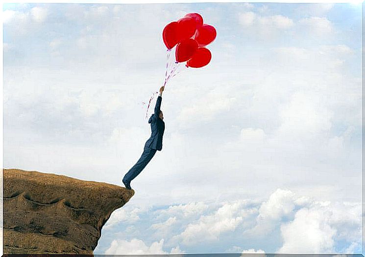 Man has unsolved problems and holds on to red balloons